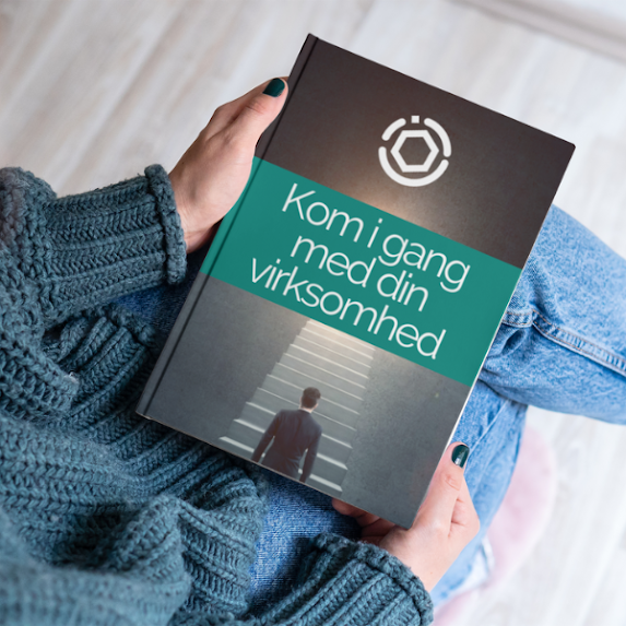 Person holder 'Komplet Guide til at Starte en Virksomhed' eBog